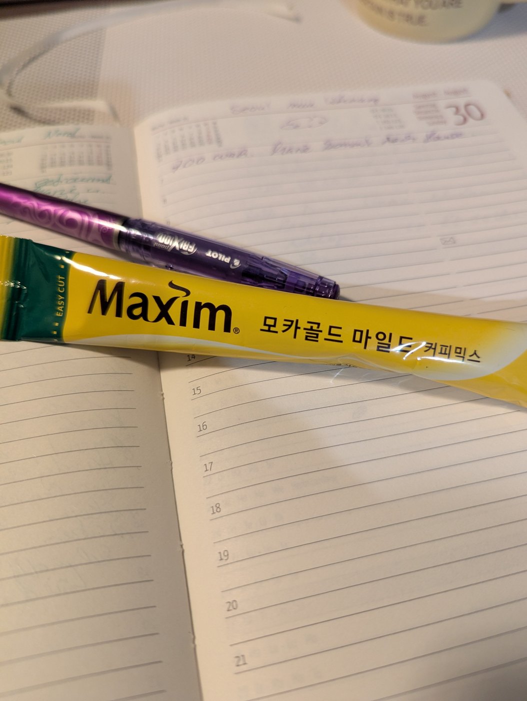 Ein Maxim Coffee-Mix-Stäbchen aus Korea auf einem Notizbuch