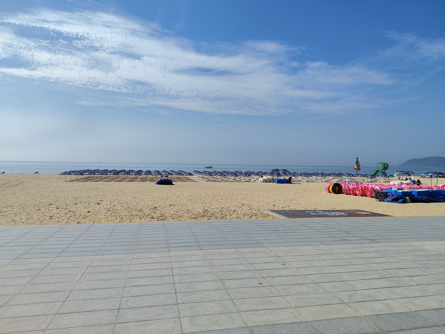 Strand von Haeundae mit Sonnenschirmen in Reih und Glied und einer abgesteckten Schwimmzone im Meer