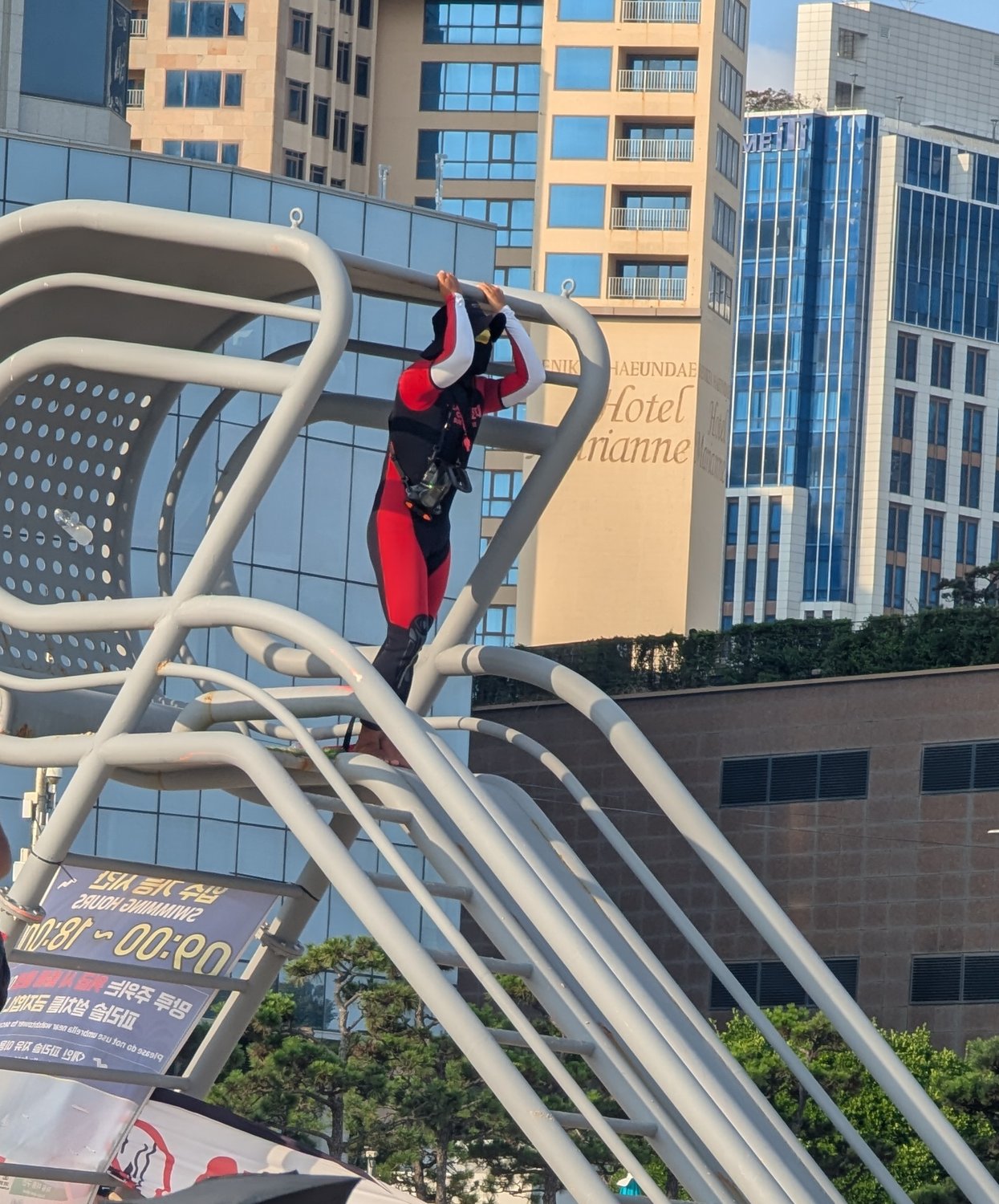 Rettungsturm am Strand von Haeundae mit Schild „Swimming Hours 09:00–18:00“ und einem Rettungsschwimmer